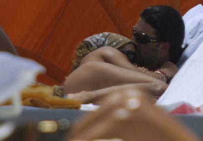 Ricardo Arjona con su novia abrazado en la playa